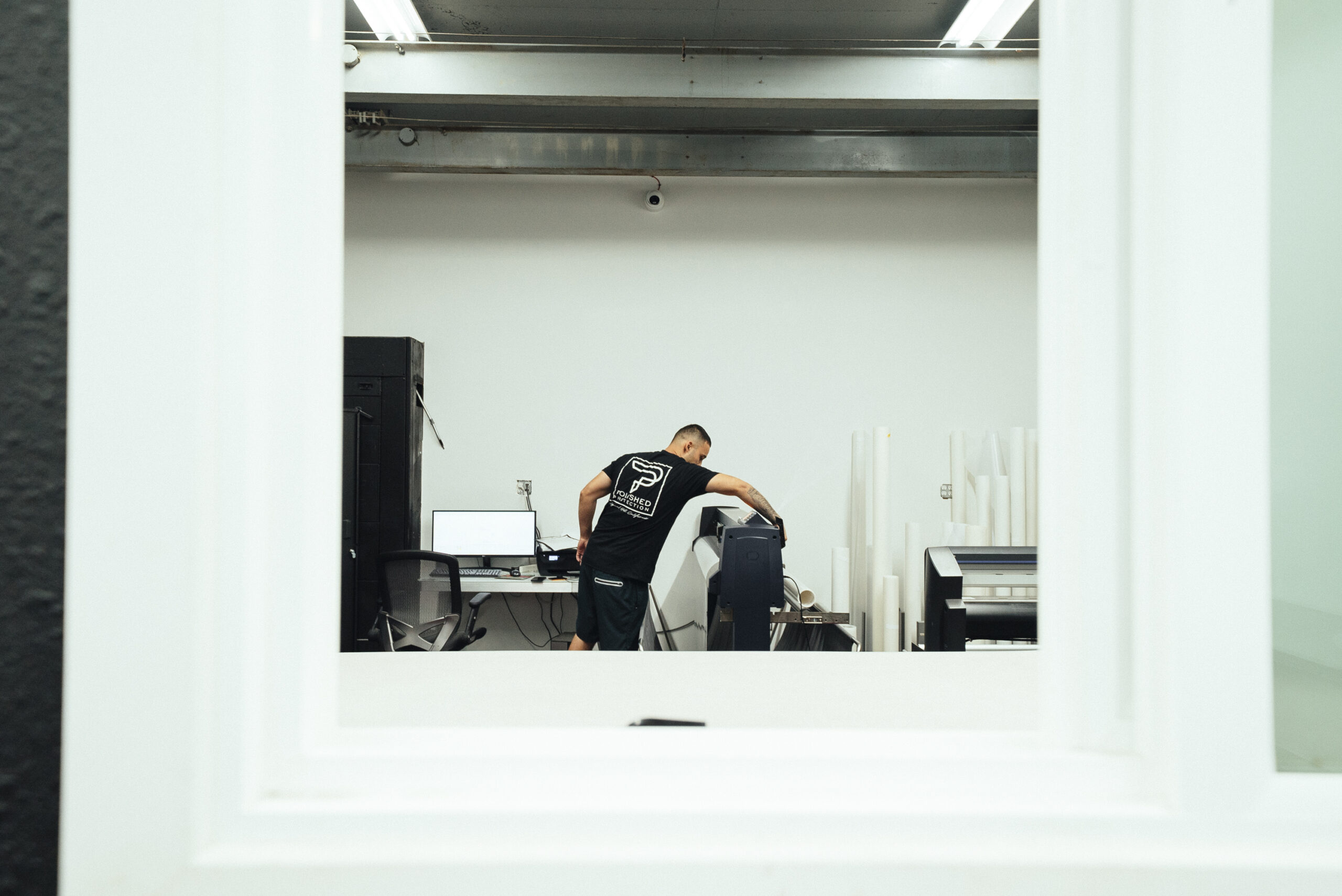 Polished Protection technician cutting film on the plotter machine